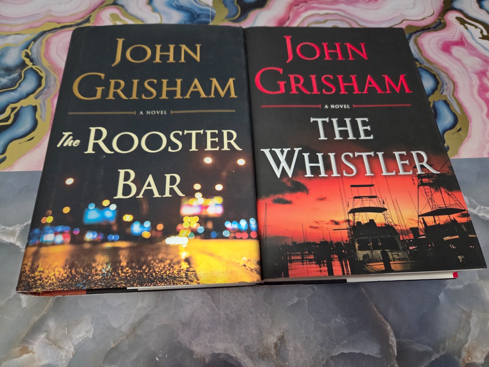 JOHN GRISHAM – LOT OF 2 HARDCOVER BOOJKS – ROOSTER BAR & THE WHISTLER